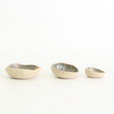 Row of three grey patterned wonky bowls in medium, small and mini sizes