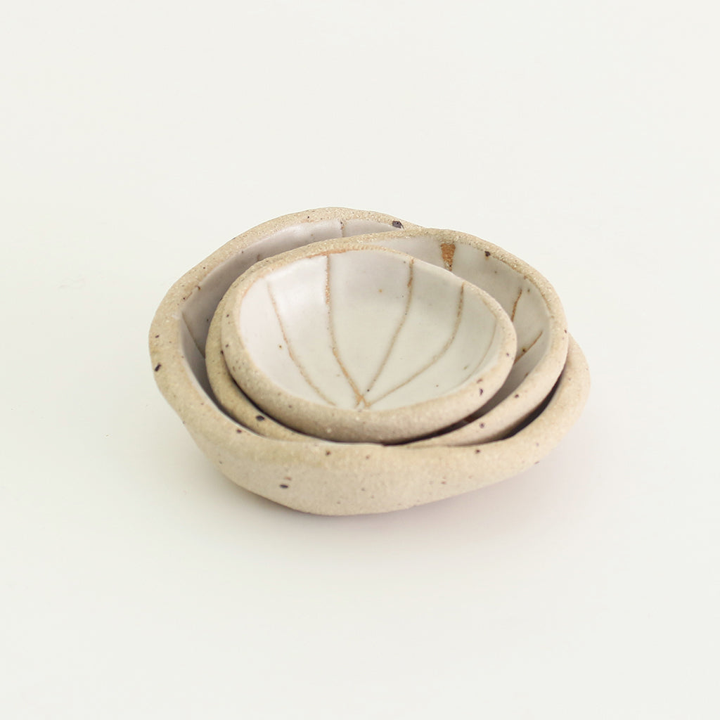 Mini and small patterned off-white wonky bowls stacked inside medium wonky bowl