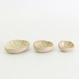 Row of three yellow patterned wonky bowls in medium, small and mini sizes