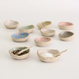 Mini wonky bowls, one with pepper granuals and one with salt and wonky spoons