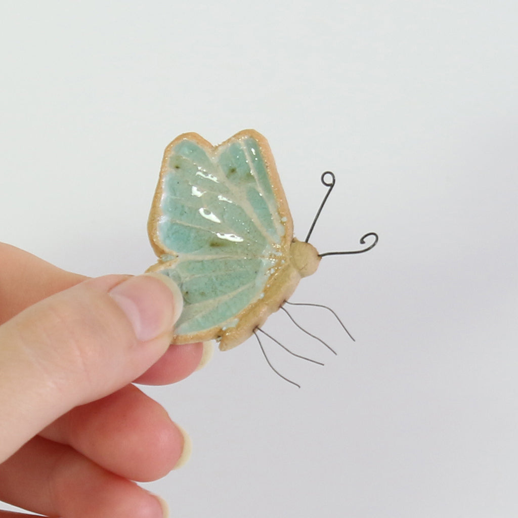 small ceramic and aqua blue glass butterfly plant decoration