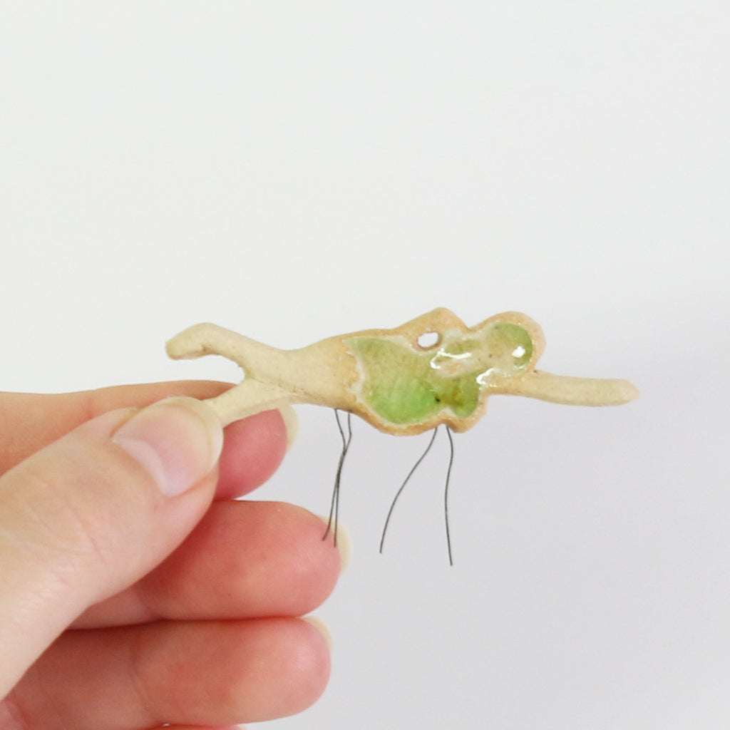 small ceramic and glass swimmer with emerald green cap and costume