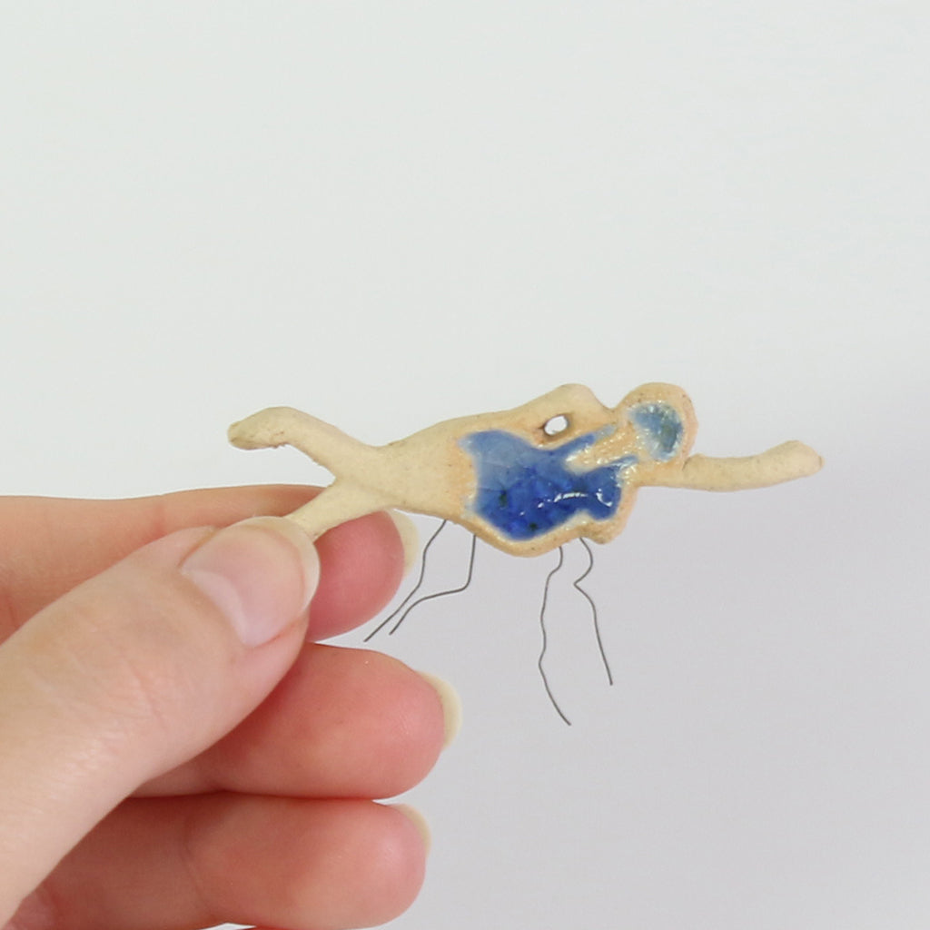 hand holding swimmer ceramic plant decoration