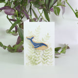 small ceramic and glass dark blue whale plant decoration, on gift card with watercolour leaves