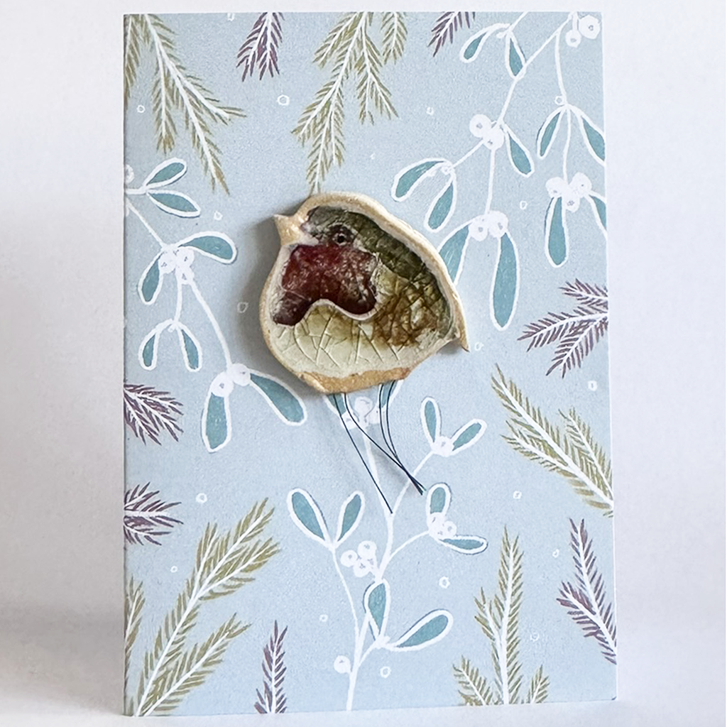 Ceramic Robin plant hugger on a floral background