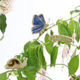 small ceramic and glass blue butterfly, green caterpillar and brown snail plant decorations on plant stems