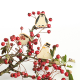 Trio of ceramic Christmas plant huggers, a penguin, robin and snowman on a branch.