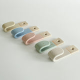 Side view of five pastel wall hooks