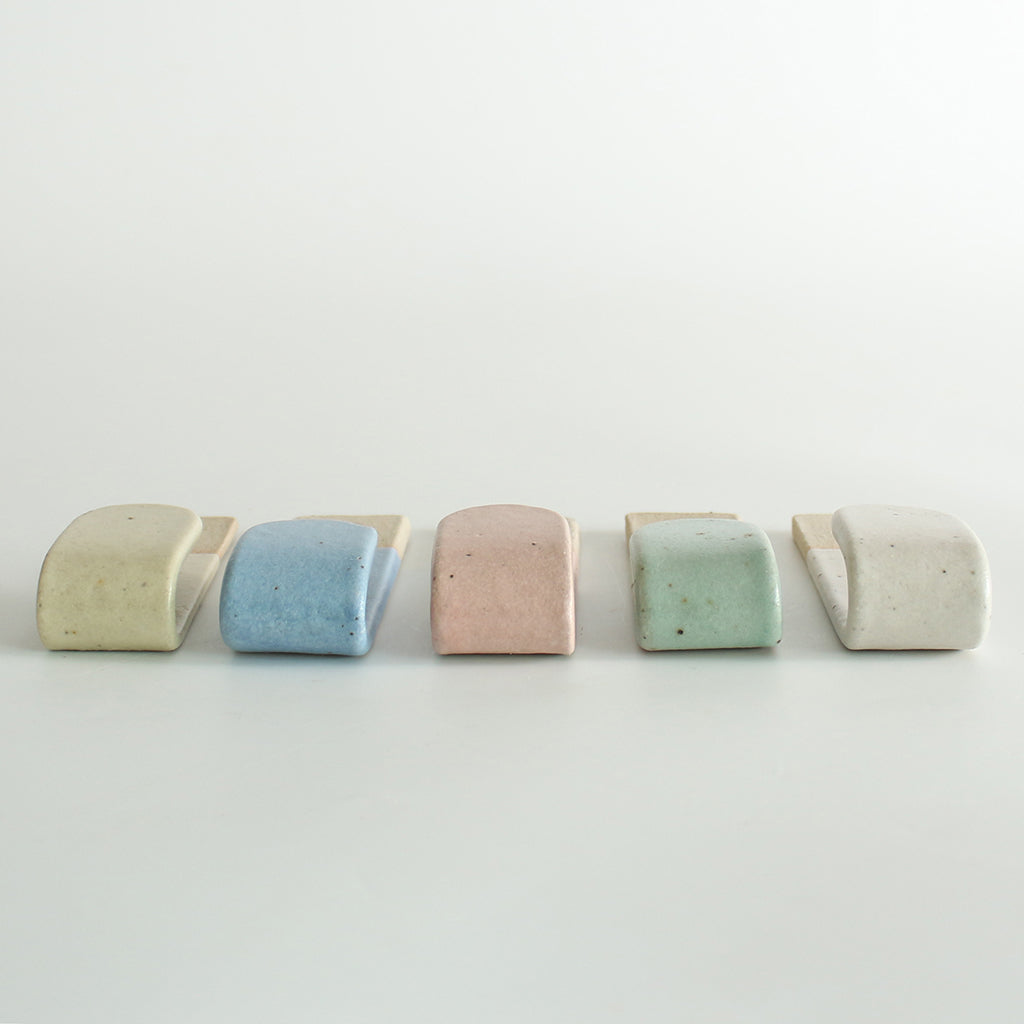 Underside view of five pastel wall hooks
