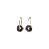 Pair of earrings with gold loops and black circular stones on a white background