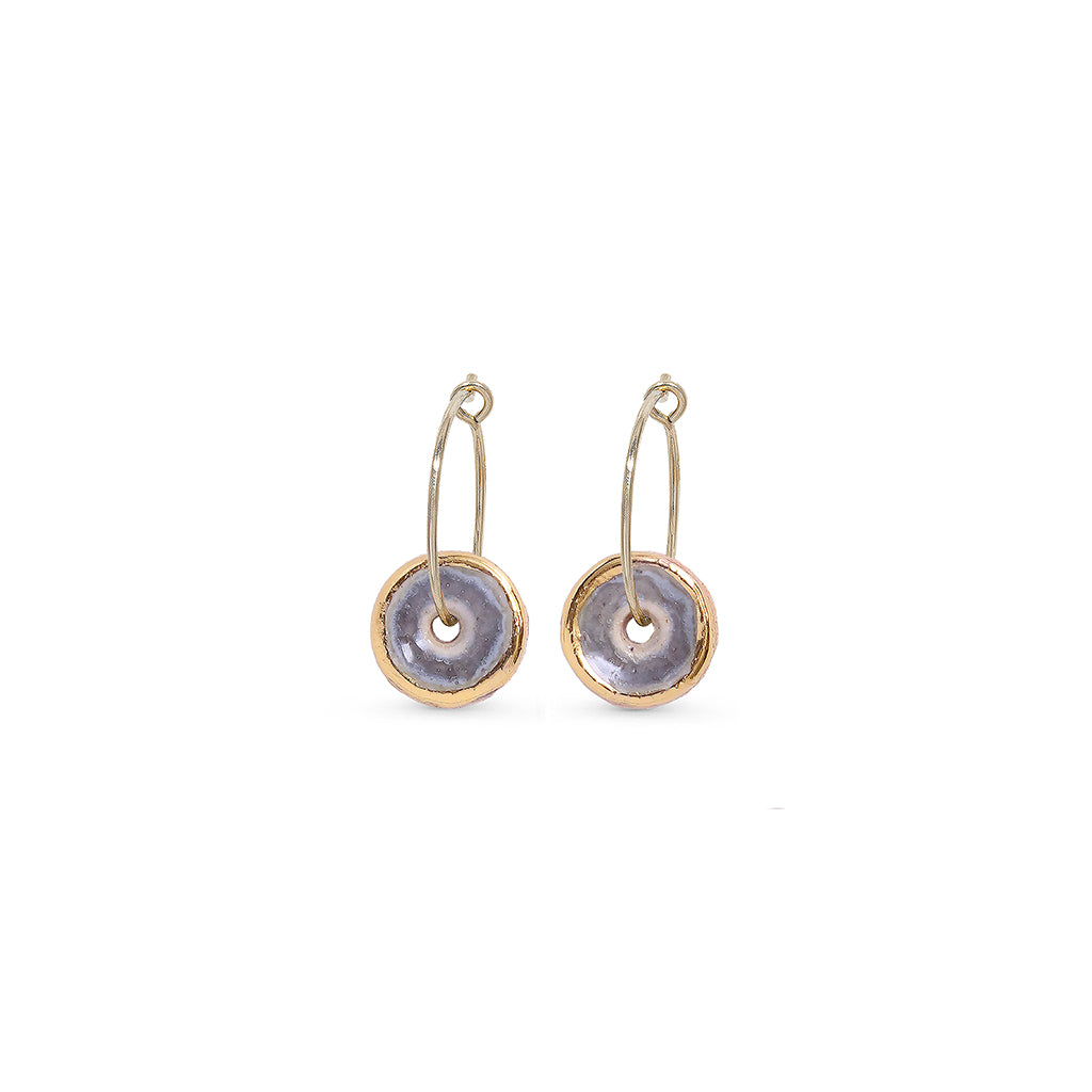 Pair of gold and purple hoop earrings with circular designs on a white background