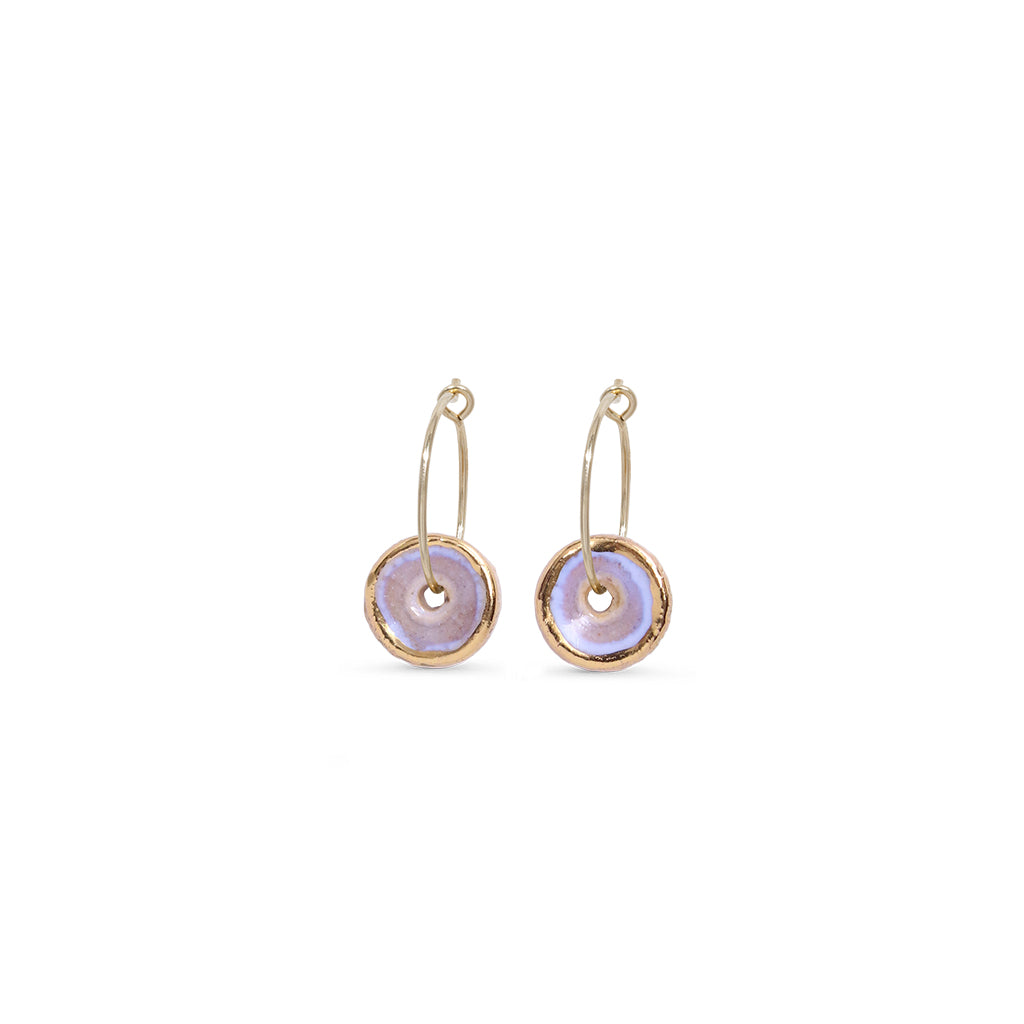 Pair of gold hoop earrings with pink circular charms on a white background