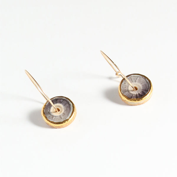 Pair of earrings with gold and purple circular designs on a white background