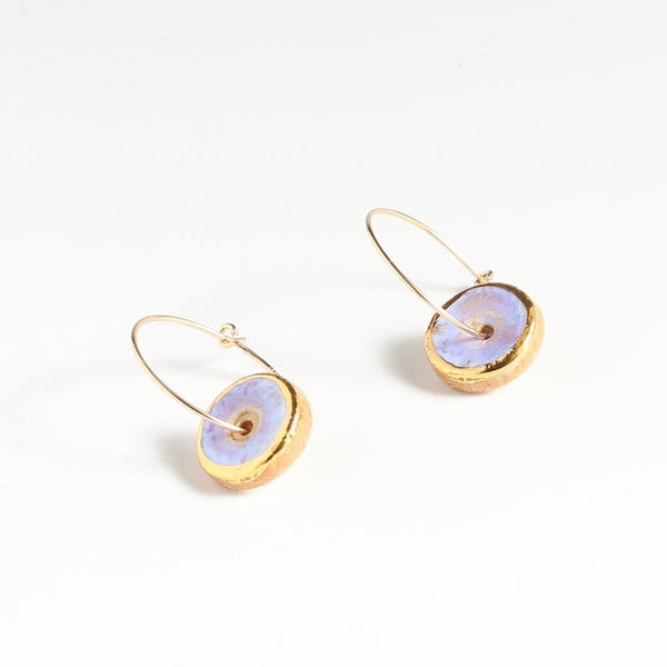 Gold hoop earrings with opal frost circular stones on a white background