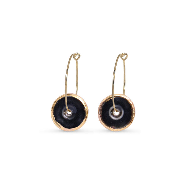 Pair of gold hoop earrings with black circular charms on a white background