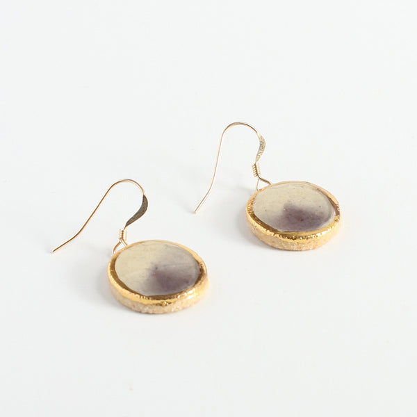 Gold-framed earrings with a purple center on a white background