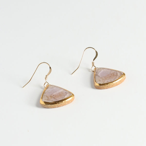 Gold-trimmed teardrop earrings on a light grey background