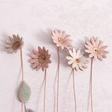 Handcrafted ceramic large pink and white  flower stems with soft glazes displayed on a white table. Each flower features a flexible copper wire stem for easy adjustment.