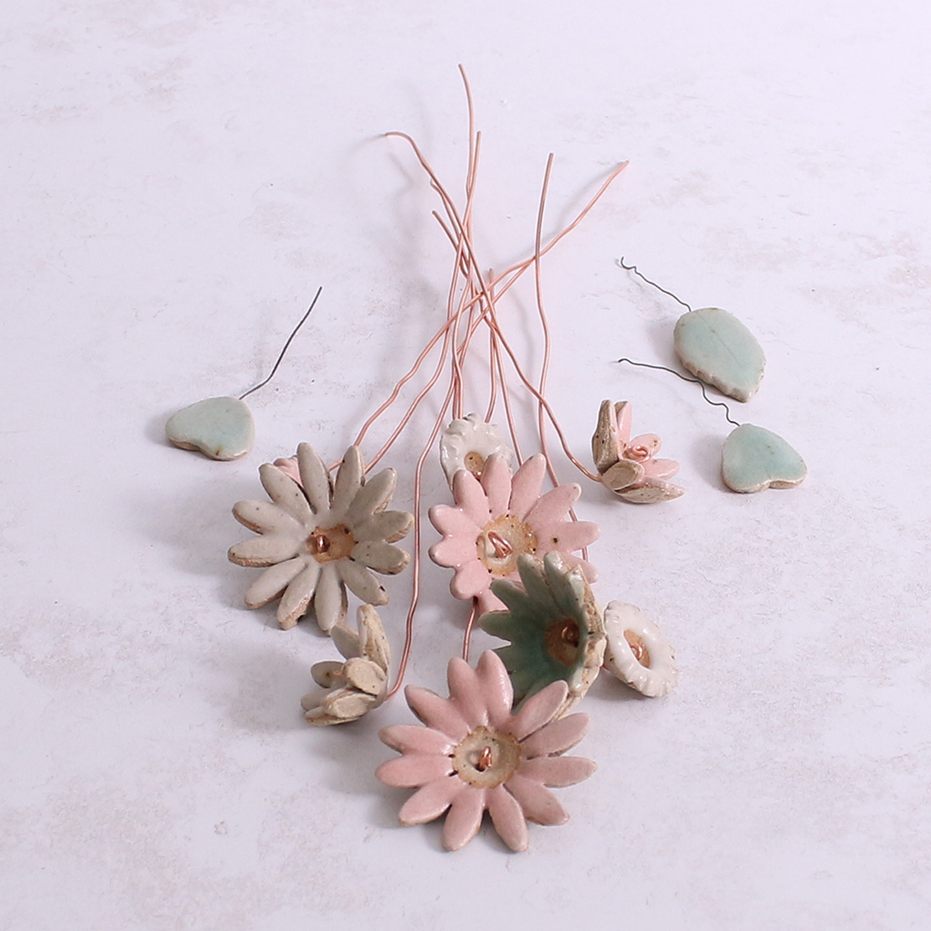 Handcrafted ceramic flower bouquet, featuring delicate pink and white wildflowers with green leaves, arranged with copper wire stems — perfect for rustic home decor.