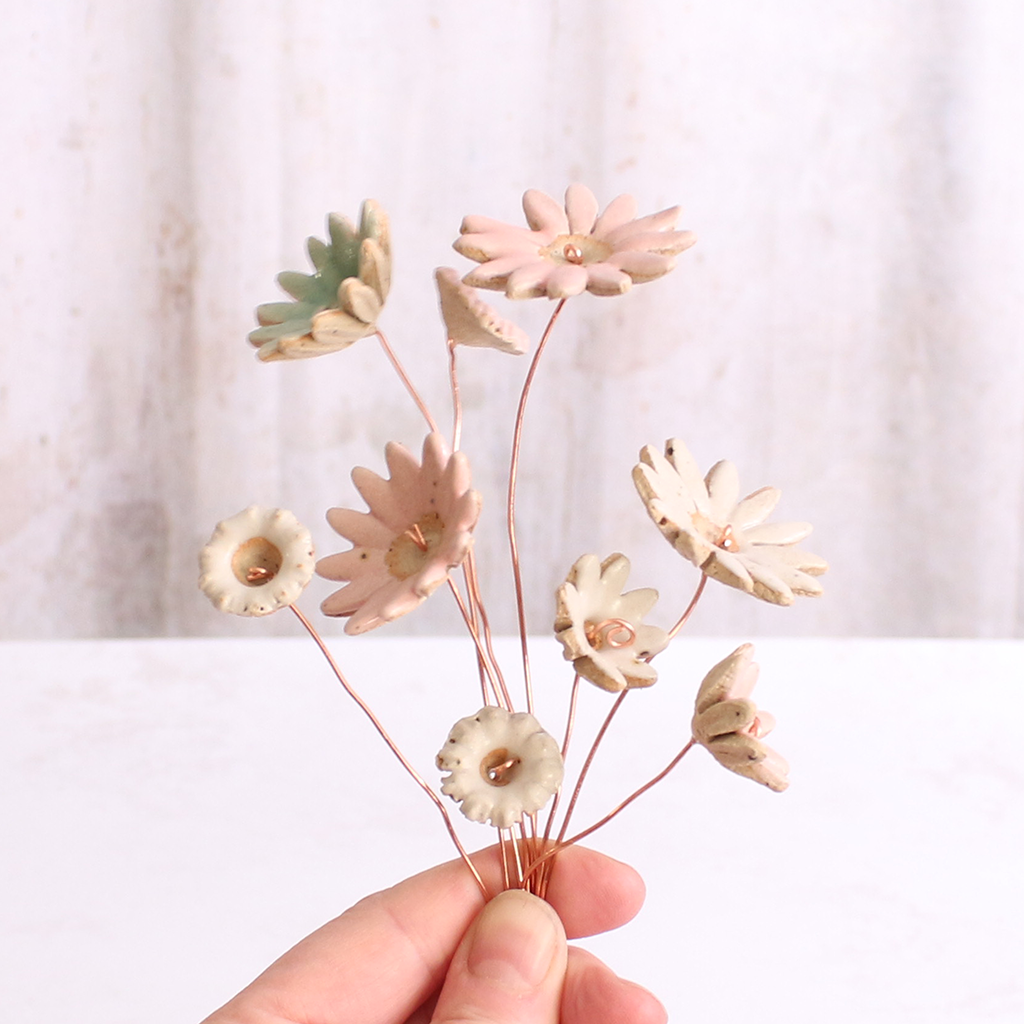 Handcrafted ceramic flower bouquet, featuring delicate pink and white wildflowers with green leaves, arranged with copper wire stems — perfect for rustic home decor.