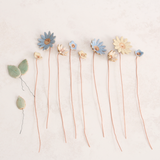 Handcrafted ceramic flower bouquet, featuring delicate blue and white wildflowers with green leaves, arranged with copper wire stems — perfect for rustic home decor.