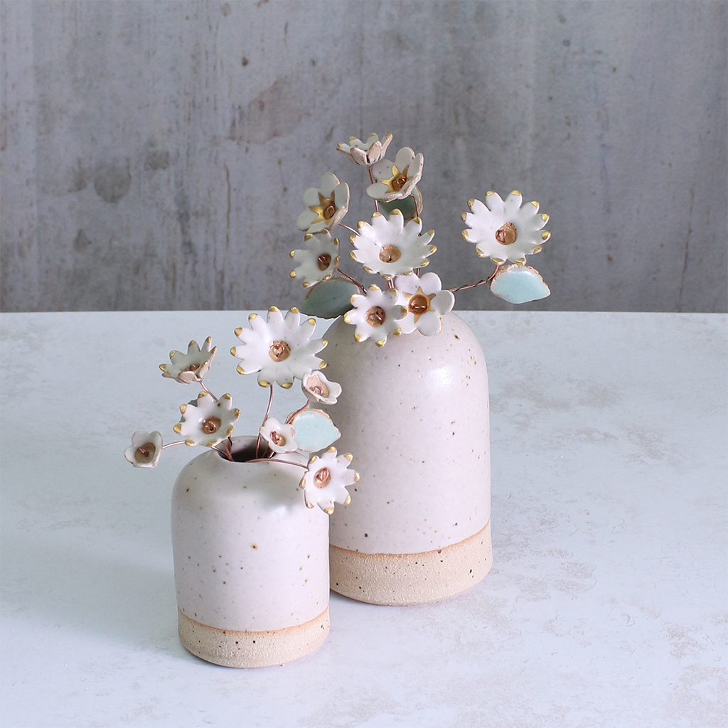 Two sets of Handmade ceramic flower bouquets in white with gold-painted petals and copper wire stems displayed in small ceramic vases
