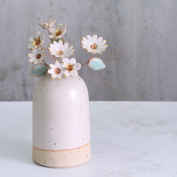 Handmade ceramic flower bouquet in white with gold-painted petals and copper wire stems displayed in a small ceramic vase.