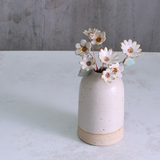 Handmade ceramic flower bouquet in white with gold-painted petals and copper wire stems displayed in a small ceramic vase.