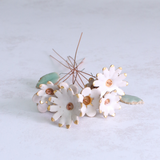 Handmade ceramic flower bouquet in white with gold-painted petals and copper wire stems displayed on a table