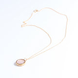 Necklace with a pink round pendant on a white background