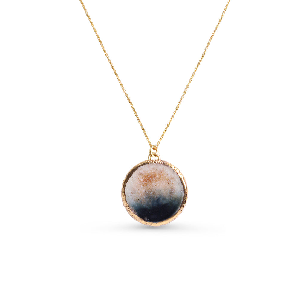 Gold Necklace with a round pendant on a white background