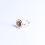 Silver ring band with a ceramic and glass charm in size small. The charm features smoky-purple coloured glass and gold lustre detailing around its outer edge. 