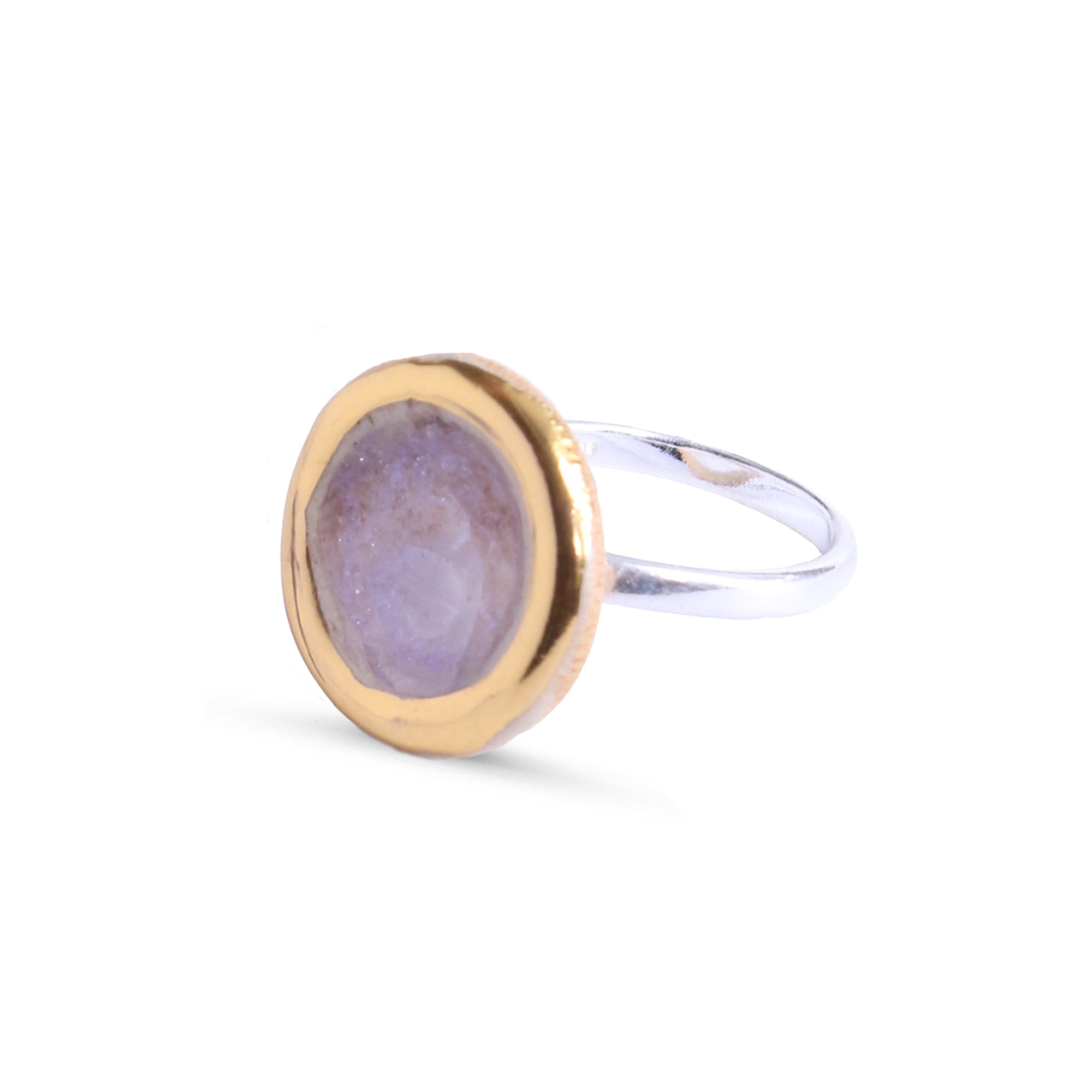 Ring with gold and silver band and pink element on a white background