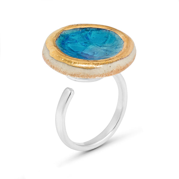Side view of turquoise blue gradient lagoon glass large round sterling silver adjustable ring outlined in gold lustre