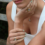 Close-up of a person wearing gold rings with pink elements on their fingers.