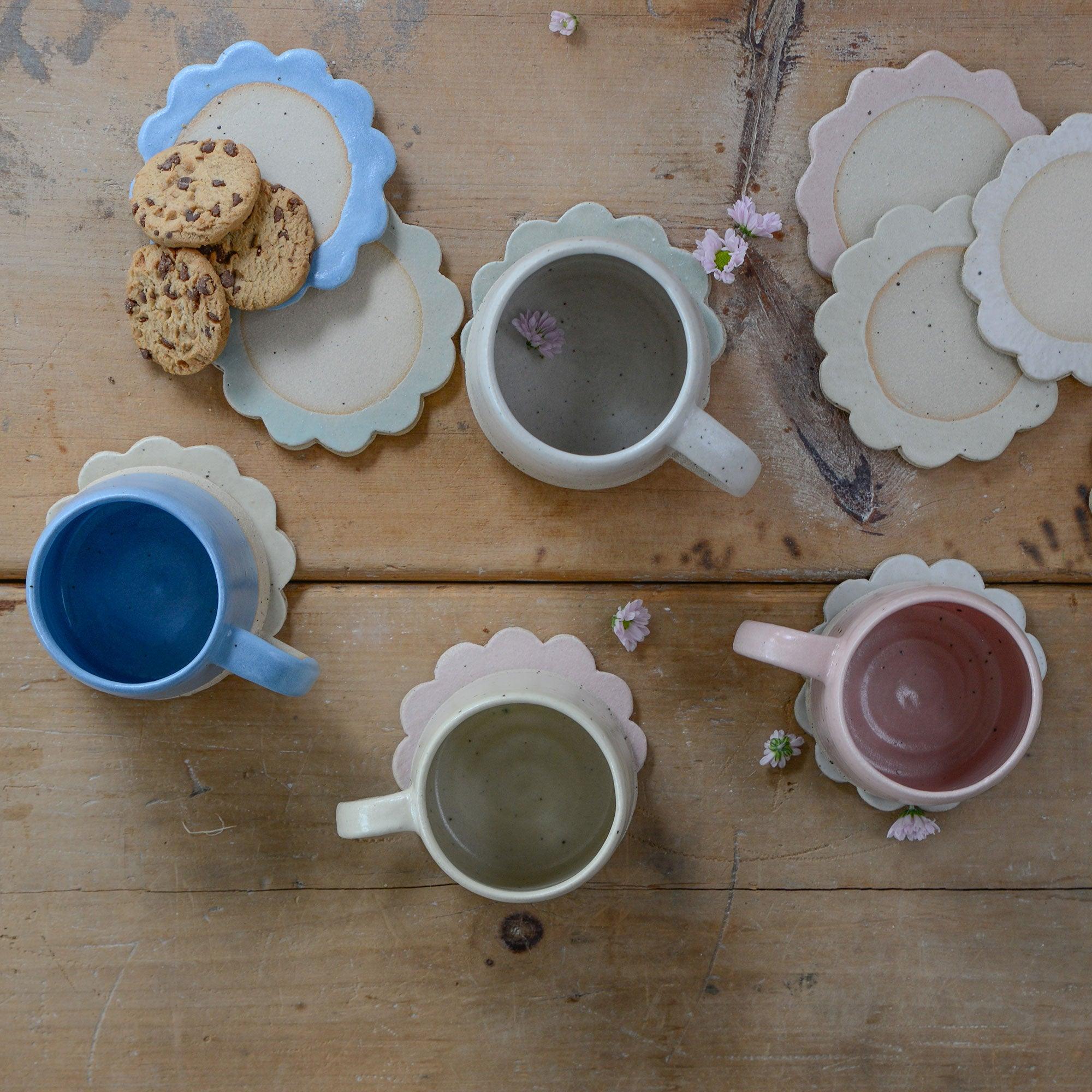Above view of mugs on flower coasters in a variety of colours
