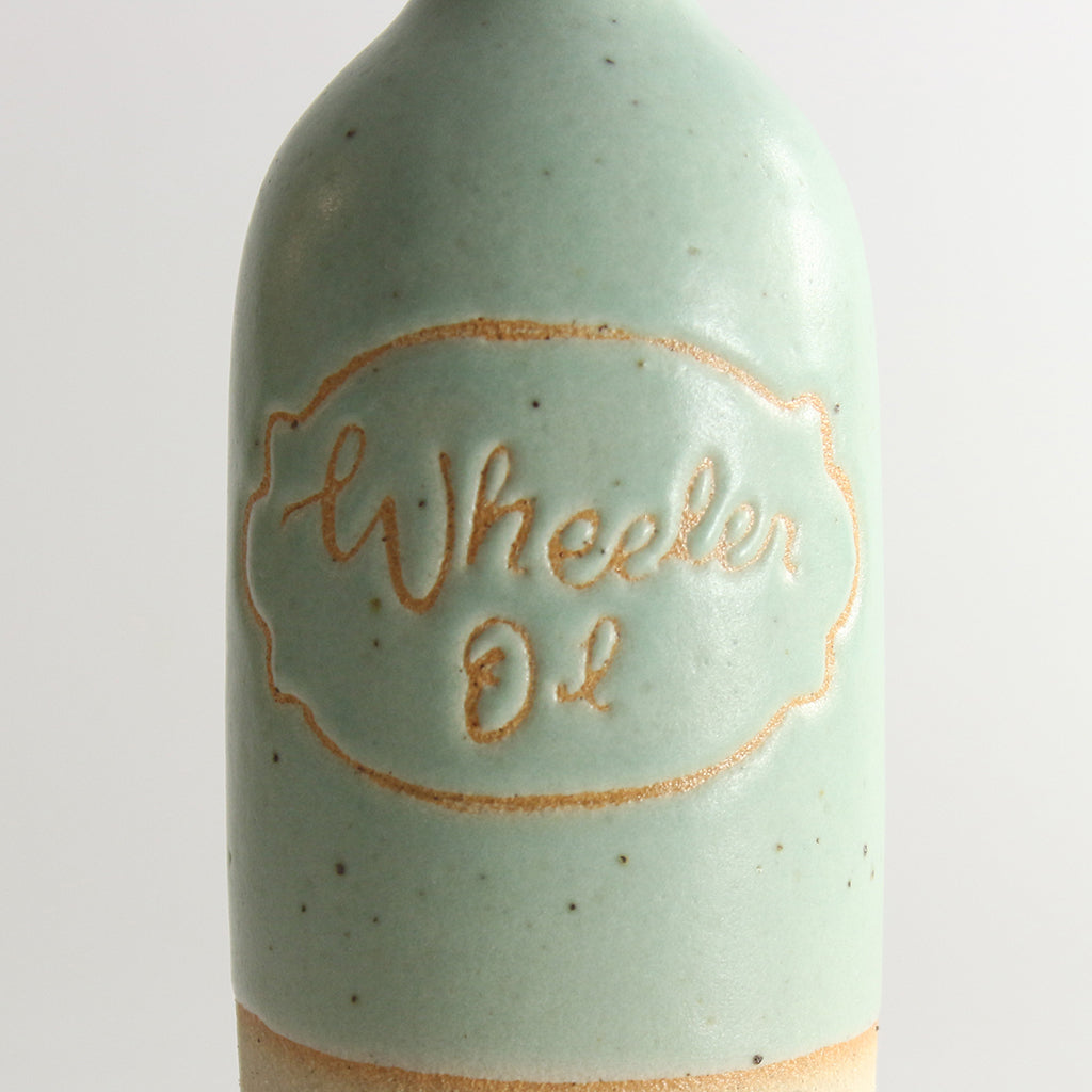 Close up of written name 'Wheeler Oil' in green glaze