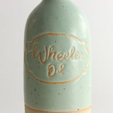 Close up of written name 'Wheeler Oil' in green glaze