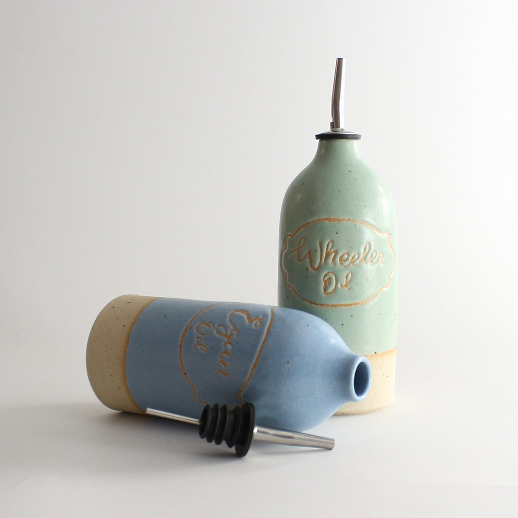 Green and blue personalised oil pourers, blue on its side