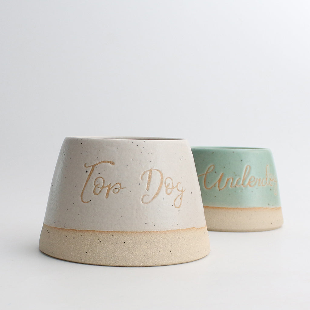 Top Dog bowl in white next to personalised green dog bowl