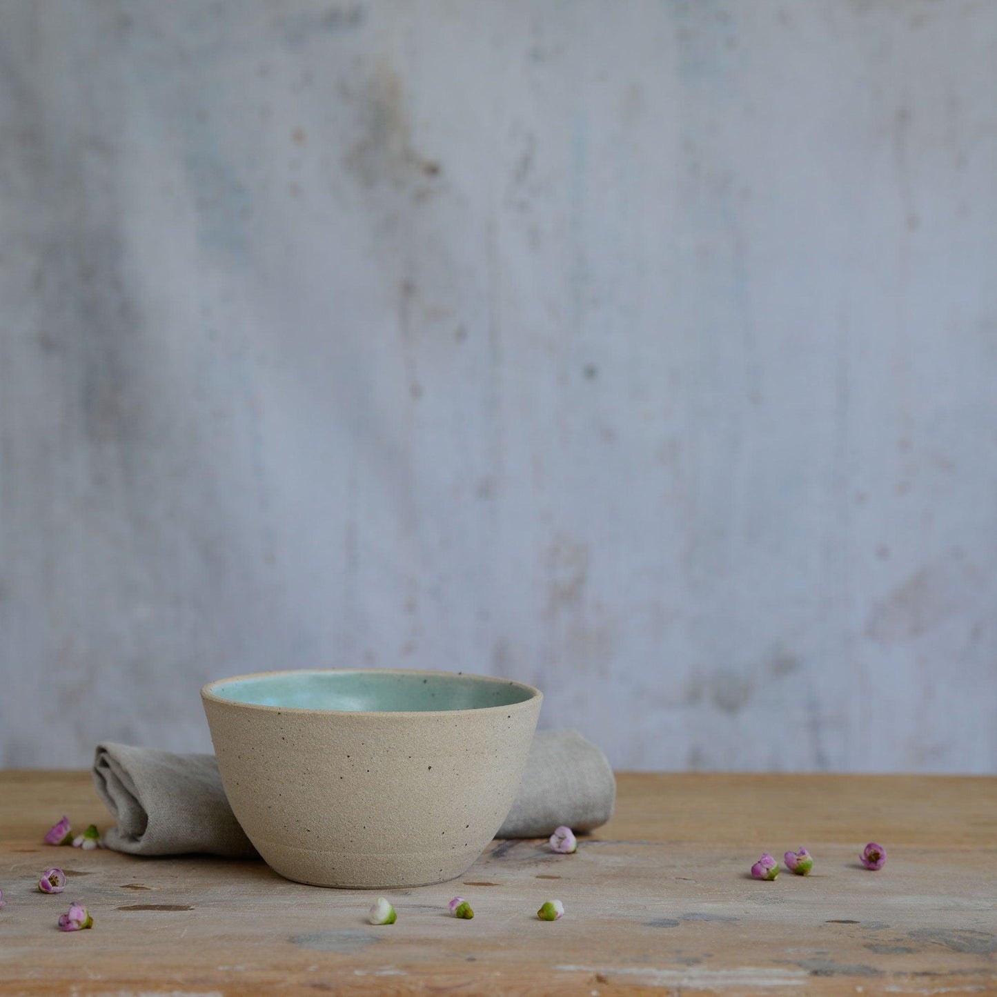 Flecked stoneware and green glaze details of bowl on table