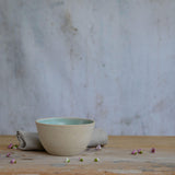 Flecked stoneware and green glaze details of bowl on table