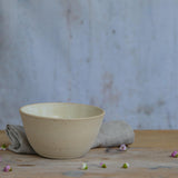 Close up of flecked stoneware and yellow glaze on bowl