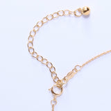 Gold extender chain pictured against a white background. 