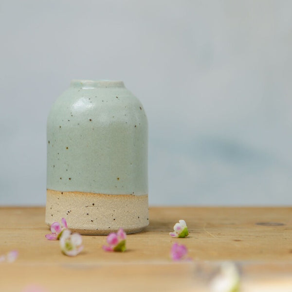 Close up of flecked stoneware and green glaze on small vase