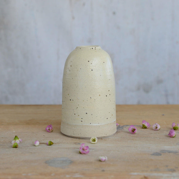 Close up of flecked stoneware and yellow glaze on medium vase