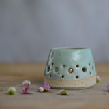 Close up of flecked stoneware and green glaze on tealight