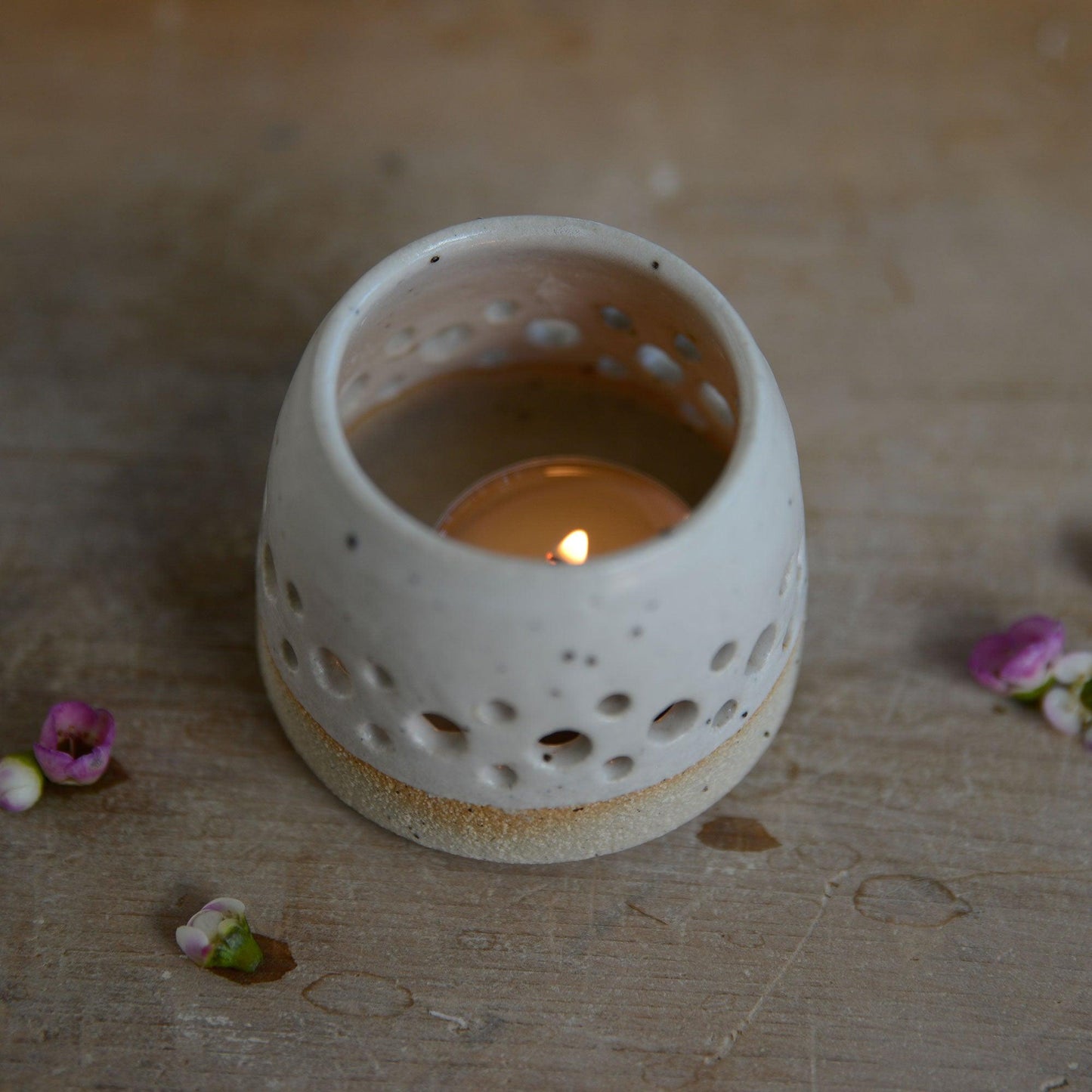 Above view of lit white tealight holder