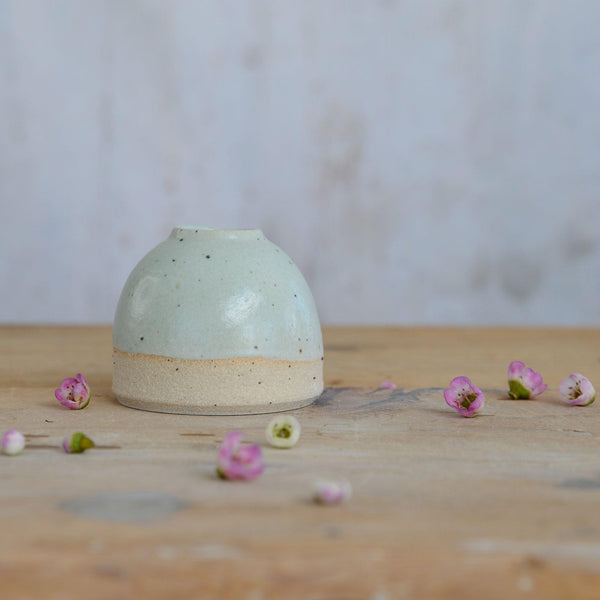 Close up of flecked stoneware and green glaze on mini vase