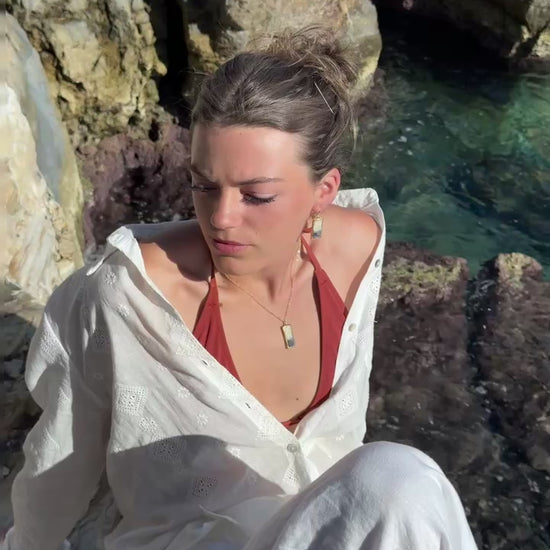 Video showing model wearing our Dusk drop pendant necklace and earrings. The ceramic jewellery features smoky purple glass with gold lustre detailing. 